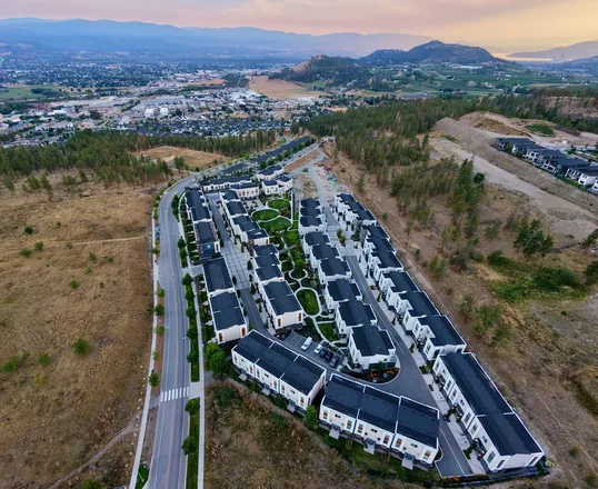 Aerial view of Academy Ridge with Okanagan Lake visible in the distance at dusk